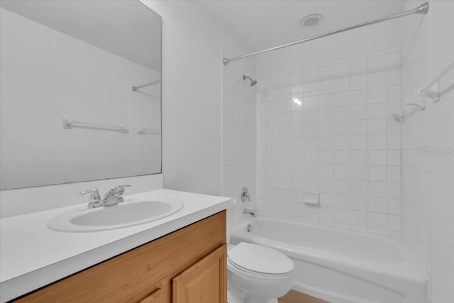 full bathroom featuring vanity, tiled shower / bath, and toilet