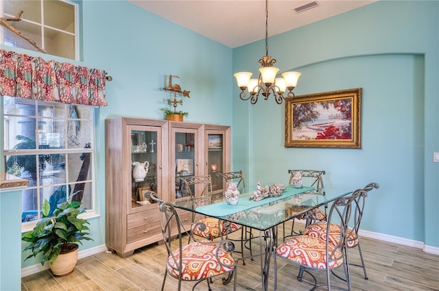 dining space featuring hardwood / wood-style floors and an inviting chandelier