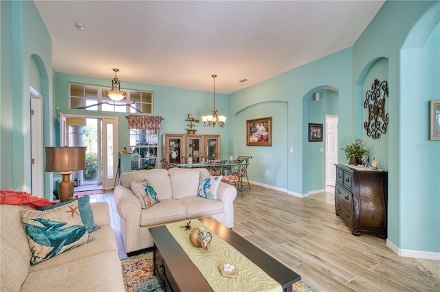 living room featuring light wood-type flooring and a notable chandelier