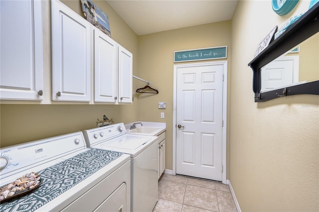 laundry area with washer and clothes dryer, light tile patterned floors, cabinets, and sink