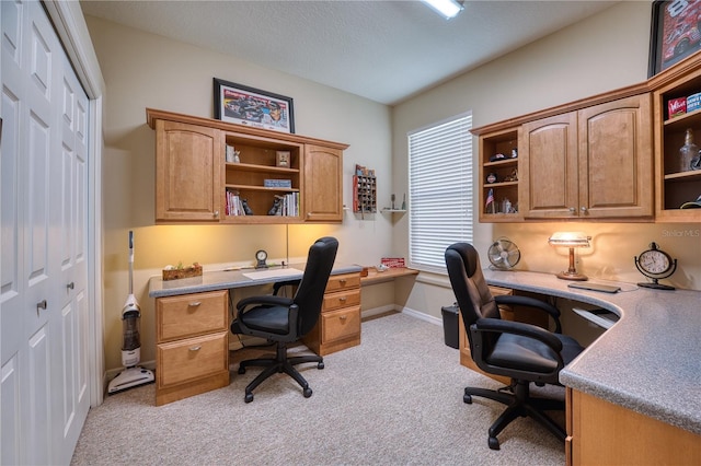 office area featuring built in desk and light carpet