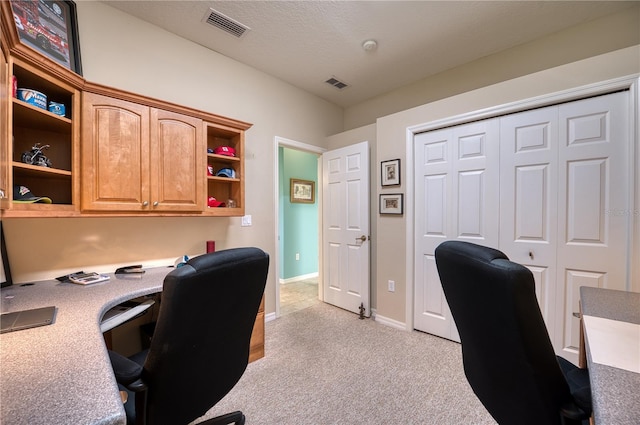 carpeted office space featuring a textured ceiling