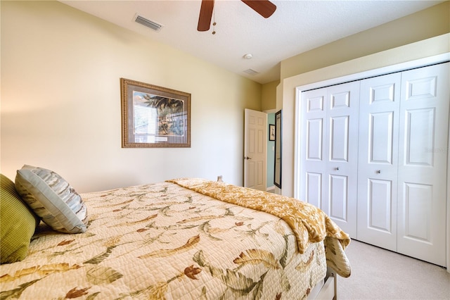 carpeted bedroom with a textured ceiling, a closet, and ceiling fan