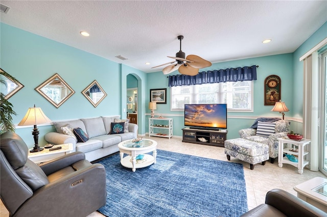 tiled living room featuring a textured ceiling and ceiling fan