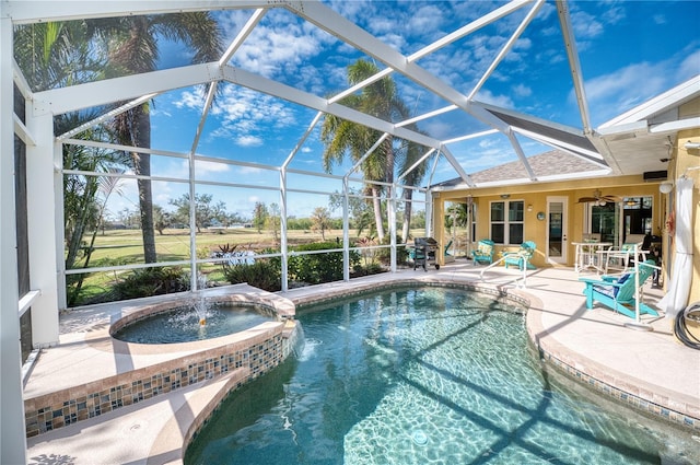 view of swimming pool featuring pool water feature, ceiling fan, a lanai, an in ground hot tub, and a patio area