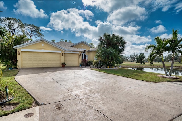 9351 Raes Creek Pl, Palmetto, FL 34221 - view of front of property with stucco siding, a water view, concrete driveway, a garage, and a front lawn