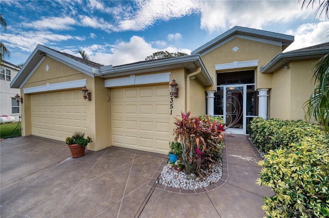 9351 Raes Creek Pl, Palmetto, FL 34221 - view of front facade featuring stucco siding, driveway, and an attached garage
