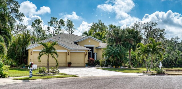 9351 Raes Creek Pl, Palmetto, FL 34221 - view of front of property featuring a garage, concrete driveway, stucco siding, and roof with shingles