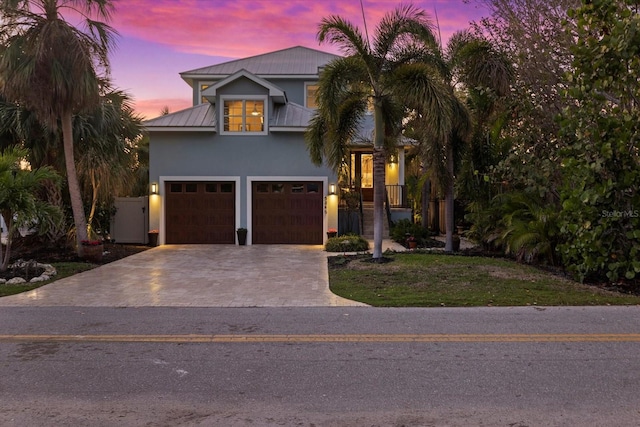 view of front of property with a garage and a yard