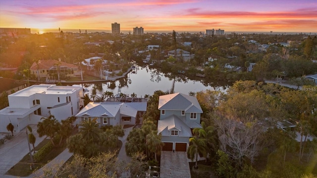 aerial view at dusk featuring a water view