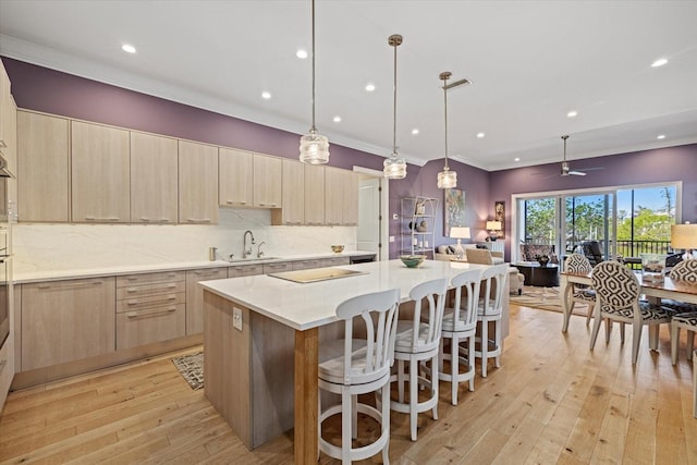 kitchen featuring light stone countertops, ceiling fan, a center island, sink, and pendant lighting