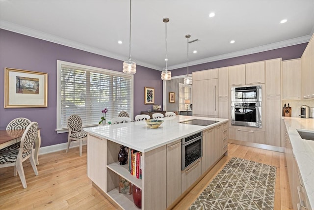 kitchen with light brown cabinetry, a center island, decorative light fixtures, and light stone counters