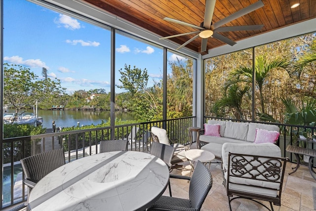 sunroom with ceiling fan, a water view, and wood ceiling