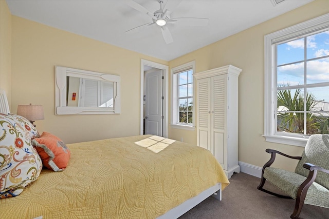 carpeted bedroom with ceiling fan and multiple windows