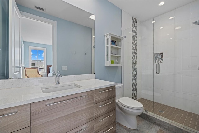 bathroom with tile patterned floors, toilet, vanity, and walk in shower