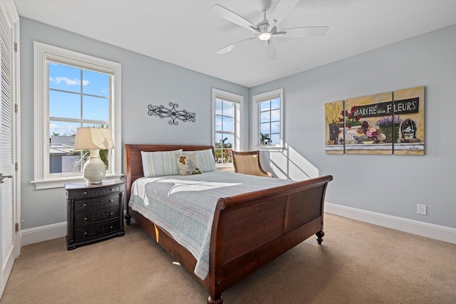 bedroom with ceiling fan, light carpet, and a closet