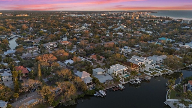 aerial view at dusk featuring a water view