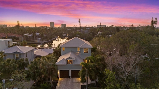 aerial view at dusk featuring a water view