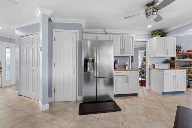 kitchen with white cabinets, crown molding, stainless steel refrigerator with ice dispenser, ceiling fan, and light tile patterned floors