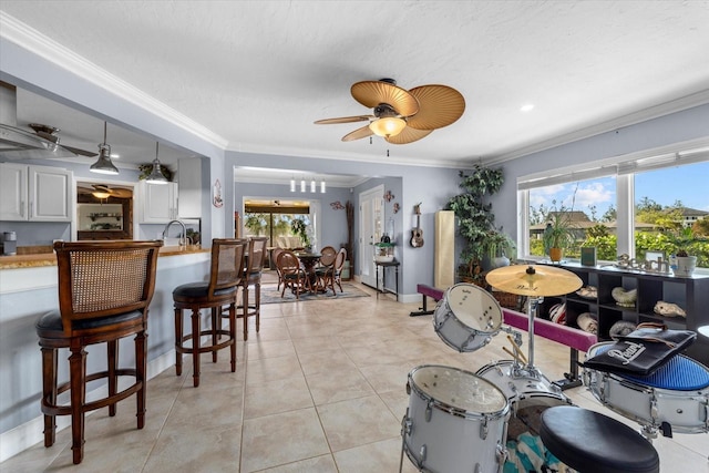 dining area featuring ceiling fan, light tile patterned floors, ornamental molding, and a wealth of natural light