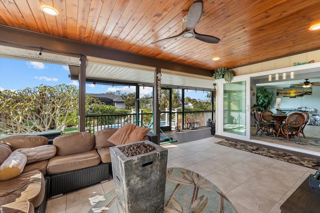 sunroom with ceiling fan and wood ceiling