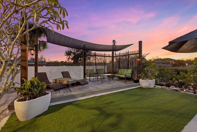 yard at dusk with outdoor lounge area and a deck