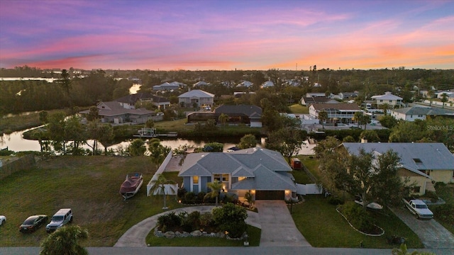 aerial view at dusk featuring a water view