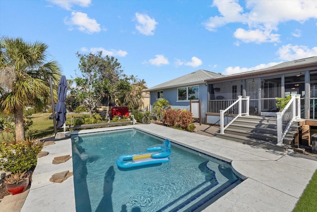 view of swimming pool with a sunroom and a patio