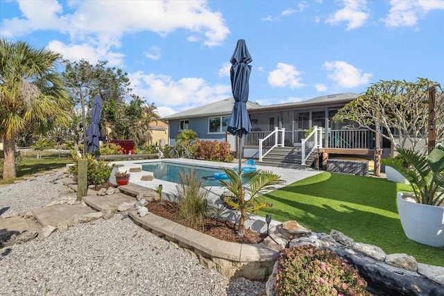 view of pool with a sunroom, a patio area, and a yard