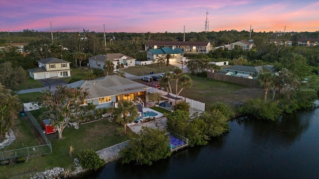 aerial view at dusk featuring a water view