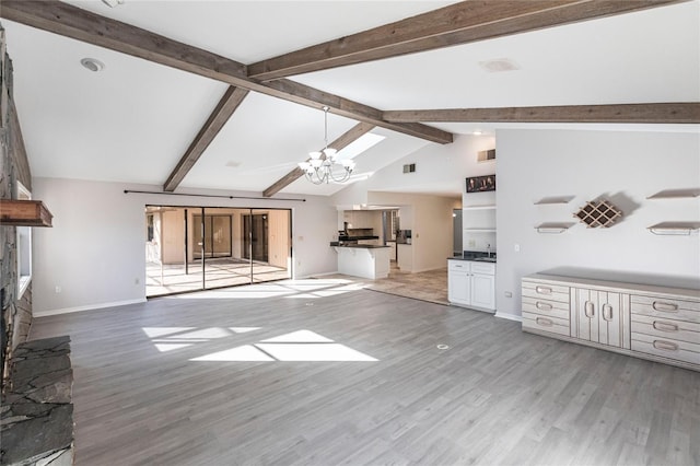 unfurnished living room featuring a fireplace, an inviting chandelier, light hardwood / wood-style floors, sink, and vaulted ceiling with beams