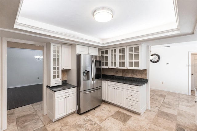 kitchen featuring a raised ceiling, white cabinets, and stainless steel refrigerator with ice dispenser