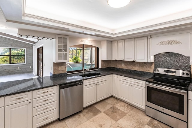 kitchen with sink, appliances with stainless steel finishes, white cabinets, and plenty of natural light