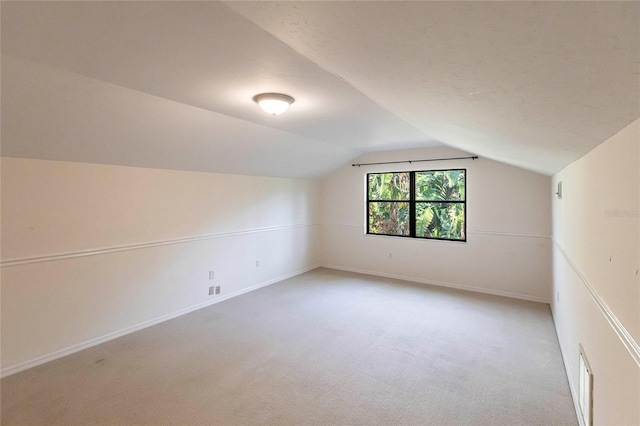 additional living space with lofted ceiling and carpet flooring