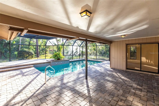 view of pool with a patio area and glass enclosure