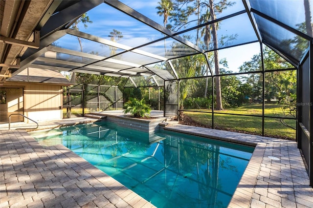 view of swimming pool with a patio area, a yard, and glass enclosure