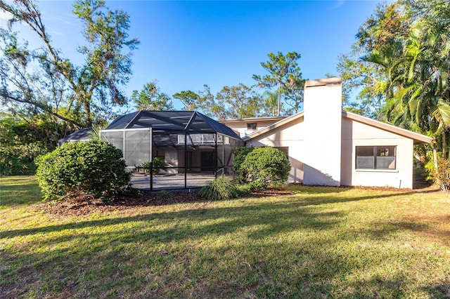 rear view of property featuring a yard and a lanai