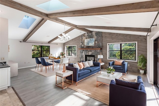 living room with a notable chandelier, lofted ceiling with skylight, and a healthy amount of sunlight