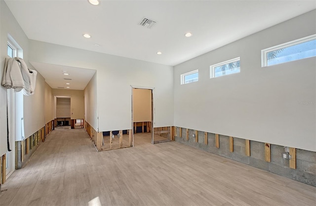 empty room with plenty of natural light and light hardwood / wood-style floors