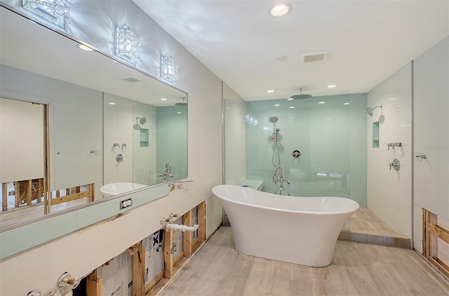 bathroom with hardwood / wood-style floors and shower with separate bathtub