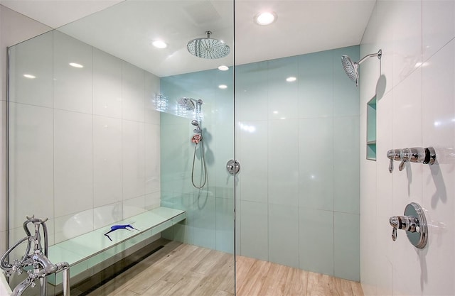 bathroom with a tile shower and wood-type flooring