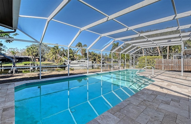 view of pool featuring a patio area, a water view, and glass enclosure