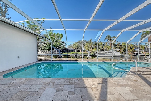 view of swimming pool featuring a water view, a patio area, and a lanai