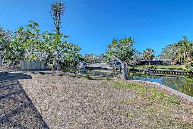 view of yard with a water view and a dock