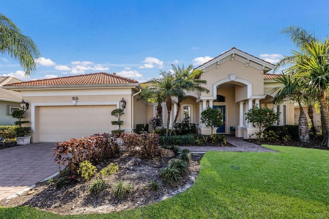 mediterranean / spanish-style home featuring a garage and a front yard