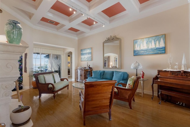 living area with beamed ceiling, wood-type flooring, ornamental molding, and coffered ceiling