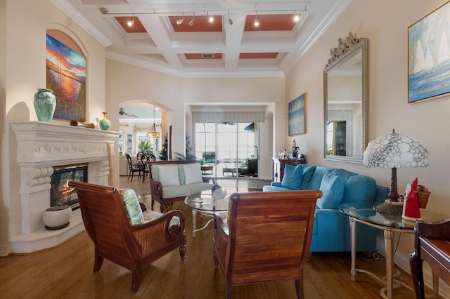 living area with beamed ceiling, ceiling fan, wood-type flooring, and coffered ceiling