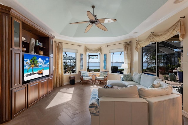 living room with parquet floors, a tray ceiling, and ceiling fan