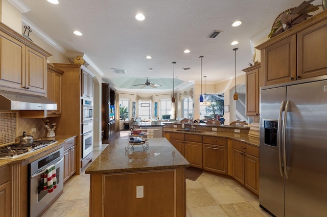 kitchen featuring a center island, crown molding, appliances with stainless steel finishes, decorative light fixtures, and kitchen peninsula