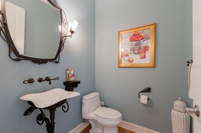 bathroom featuring hardwood / wood-style flooring and toilet